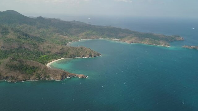 Aerial view coastline with tropical beach, island Limbones, lagoons and coral reefs. Neela cove, Philippines, Luzon. Coast ocean with turquoise water. Tropical landscape in Asia.