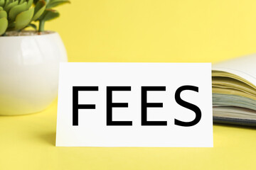 fees, text on white paper on a yellow background