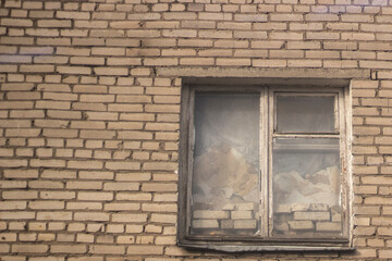 The window is bricked from the inside. Abandoned house. White brick wall with a window.