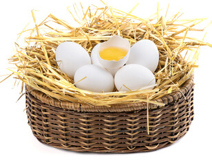 in a basket with a nest of white chicken eggs on a white background