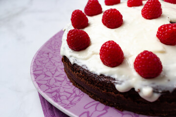 Delicious chocolate cake with cheese cream on top and raspberries. Christmas cake. Selective focus. Copy space.