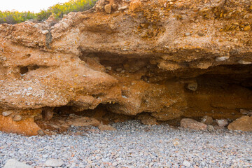 Beautiful natural cave near the shore. Prehistoric excavation on a stone beach. Neanderthal era.  