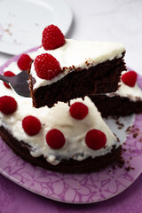 Delicious chocolate cake with cheese cream on top and raspberries. Christmas cake. Selective focus. Copy space.