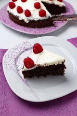 Delicious chocolate cake with cheese cream on top and raspberries. Christmas cake. Selective focus. Copy space.