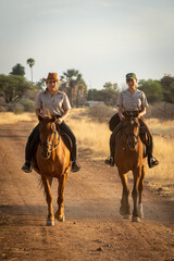 Blonde and brunette ride along dirt track