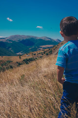 Naklejka premium The boy looking sadly over the distant pastures.