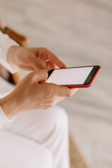 Woman holding a mobile phone with a red case