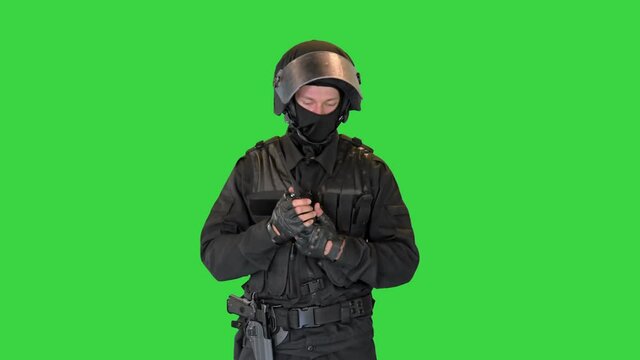 Swat soldier in full uniform using radio on a Green Screen, Chroma Key.