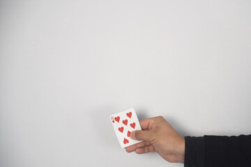 Concept of performances, entertainments, shows and circus. Closeup hands of magician is making trick with changing card on grey background.