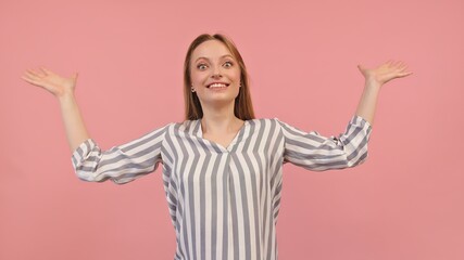 Young surprised woman with outstretched hands isolated on pink background. Unexpected guest visiting. High quality photo