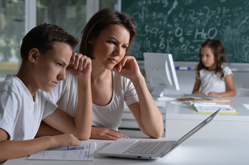 Children at school sit in the classroom with teacher