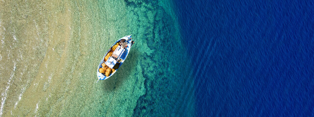 Aerial top view photo of traditional fishing boat anchored in turqoise bay and beach of Balos,...
