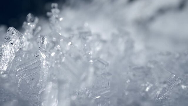 Camera moves through the snow crystals. Transparent snow ice formations background. Real snow frost figures. Winter nature sliding shot. High quality, UHD