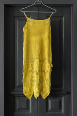 Yellow  knitted dress on the background of wooden doors.Illuminating Yellow and Ultimate Gray.