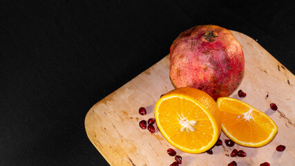 Sliced orange and pomegranate on a wooden Board