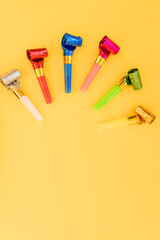 Birthday party whistles on color background.Colorful celebration pattern with party blower horns....