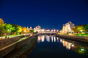 Hiroshima Skyline by night on the side of Motoyasu river in Japan with the ruin of the Atomic Bomb Dome, the historic remains of the atomic blast