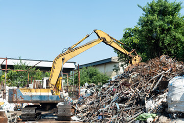 Yellow excavator in recycling plant