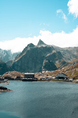Bergsee mit Haus und Panorama im Hintergrund