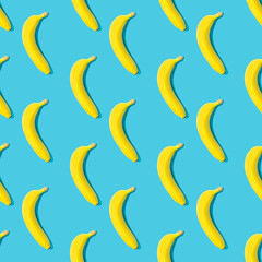 Fototapeta na wymiar Seamless pattern with yellow ripe bananas on blue background. Fruit abstract seamless pattern.