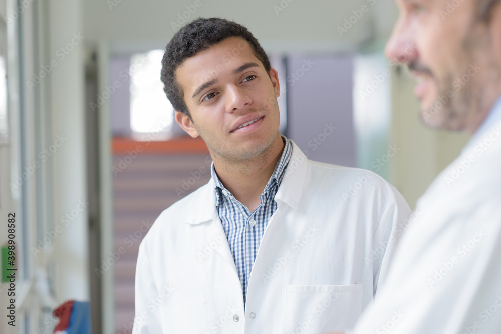 Wall mural male doctor looking at colleague