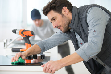 man cleaning a kitchen hob after installation
