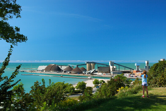 Girl viewing the Goderich salt mine plant with binoculars