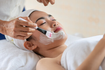 Beautiful Asian woman in mask on face in spa beauty salon, enjoying and relaxing time, skin care and healthcare concept