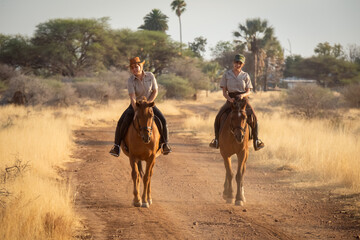 Blonde strokes horse on track beside brunette