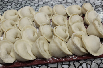 plate of homemade dumplings, and not boiled standing on the board.