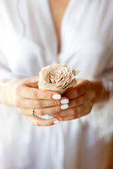 Bride with manicure holding buttonhole  