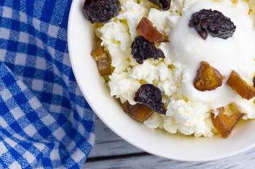 Loose cottage cheese in a cup with yogurt and chopped dried fruits. Delicious and healthy snack.