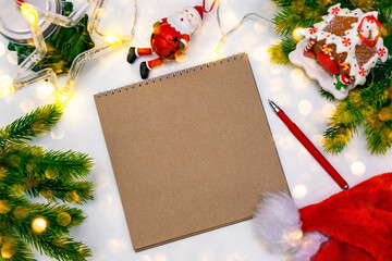 Empty kraft paper notebook with red pen, mockup. A child writing a letter or wish list for Santa...