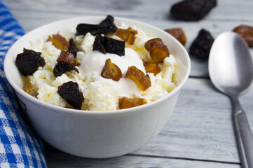 Loose cottage cheese in a cup with yogurt and chopped dried fruits. Delicious and healthy snack.