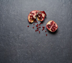 Pomegranate isolated on dark grey stone background. Top view.