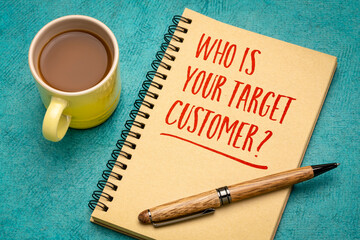 Who is your target customer? Handwriting in a notebook with a cup of coffee. Starting business and marketing concept.