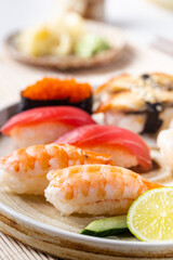 Set of sushi and maki on plate with soy sauce and chopsticks on white background. Top view with copy space