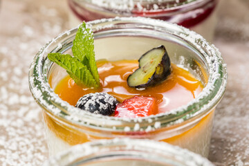 assorted panna cotta with jam decorated with fruit