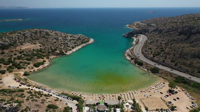 Aerial drone videoof famous mojito bay and beach in Athens riviera seaside road, Attica, Greece