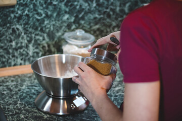 cook weighs the sugar on an electronic scale to determine the exact weight. Adding a sweet flavour to the gingerbread dough. Baking Christmas cookies