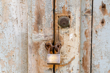 An old wooden door with a worn padlock.