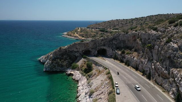 Aerial drone video of Tunnel in Athens riviera seaside road known as hole of Karamanlis or "Tripa of Karamanlis", Attica, Greece