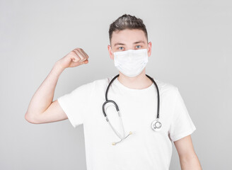 Pretty Hispanic male doctor in uniform flexing his arms acting like a superhero