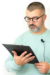 Portrait of businessman coach with microphone and clipboard, mentor speaker holding online lesson