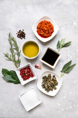 Set of spices and sauces for cooking food  olive oil, soy sauce, harissa, capers, pink pepper coarse salt rosemary sage garlic