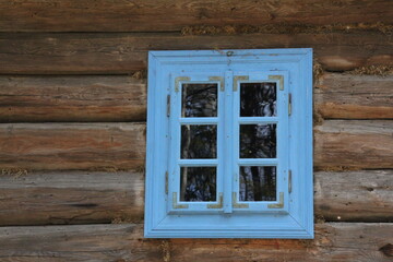 a blue wooden window, mounted in a wooden country cottage