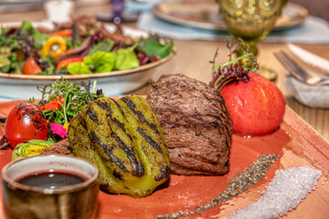 Juicy steak with aromatic grilled tomatoes, peppers, corn and herbs. 