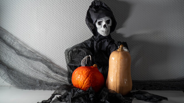 
Death, holding a pumpkin and a butternut, autumn, halloween