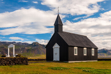 Fototapeta na wymiar Black church of Budir (Búðakirkja in icelandic) is located on the southern side of the Snaefellsness peninsula in Iceland. Picture taken in summer in a rare sunny day