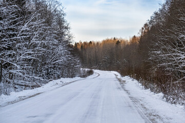Obraz premium winter road through the forest, which was cleaned after a snowfall